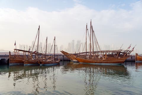 Traditional boats in Dhow harbour and the modern city of Doha in background, Qatar